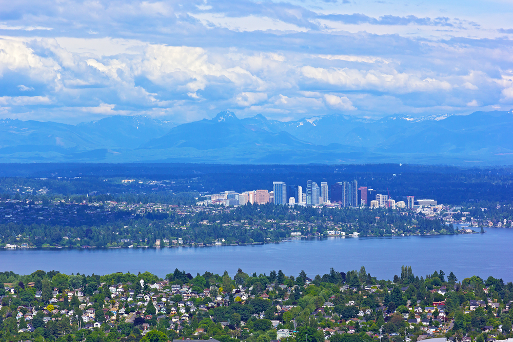 Scenic panorama of suburban Seattle with mountains range on a horizon. Urban development in Seattle with a natural beauty of surrounding mountains and water.