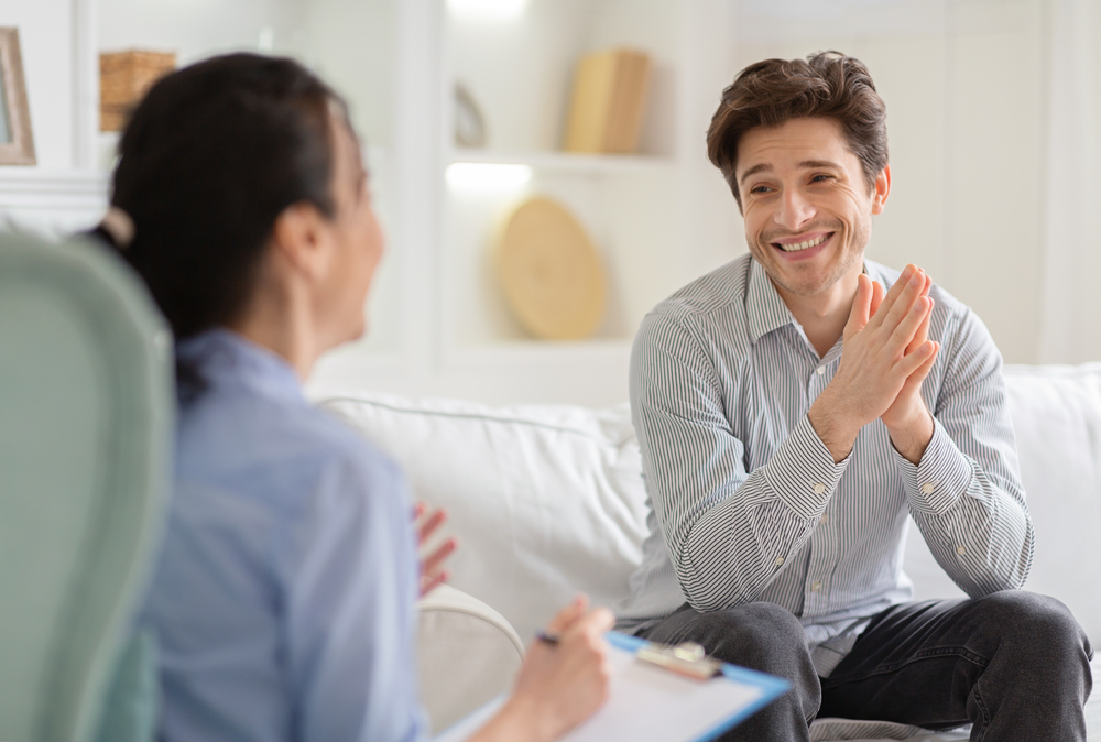 Thankful man sharing his plans with psychotherapist during rehab therapy