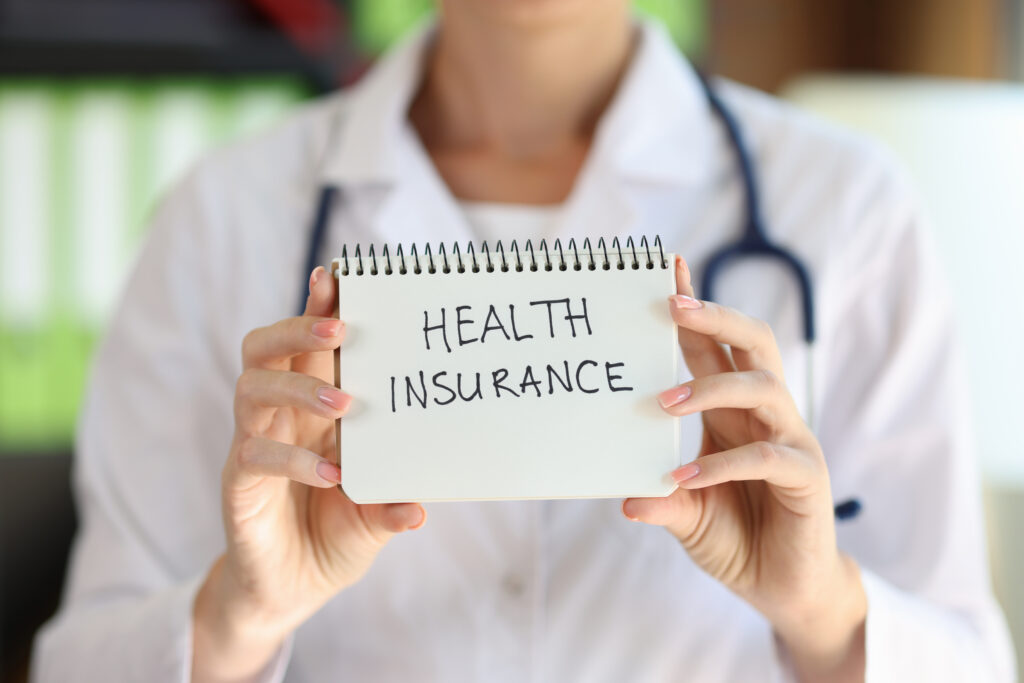 woman holding sign with the words health insurance 