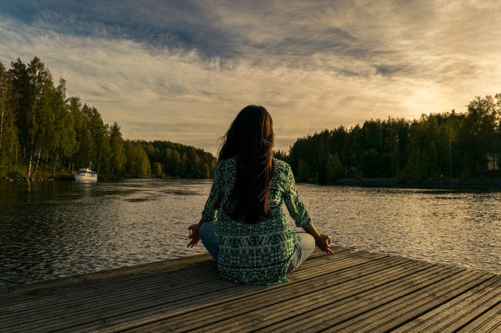 holistic rehab for drug addiction, person meditating by lake