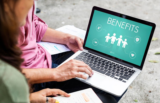 Two women looking at virtual addiction treatment benefits on a laptop